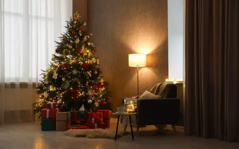 Un accogliente soggiorno con un **albero di Natale stile scandinavo** illuminato, circondato da regali. Una poltrona invitante e una lampada creano un'atmosfera calda.