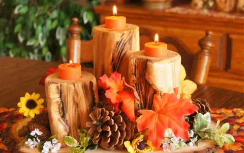 Un semplice centrotavola autunnale con tronchi di legno, candele arancioni, pigne e foglie colorate.