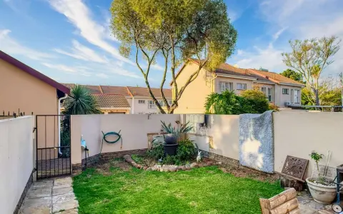 Giardino con prato verde, piante e un piccolo laghetto. Idee per come abbellire un giardino con pochi soldi, con mobili riciclati e decorazioni fai-da-te.