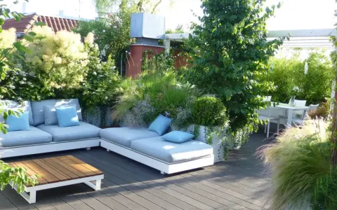 Un lussureggiante giardino sul terrazzo fai da te con divani comodi, tavolino in legno e un tavolo da pranzo.