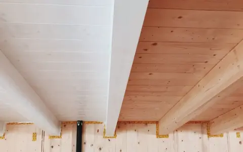 Soffitto perlinato sbiancato con travi a vista in legno naturale. Un contrasto di finiture che crea un ambiente caldo e luminoso.