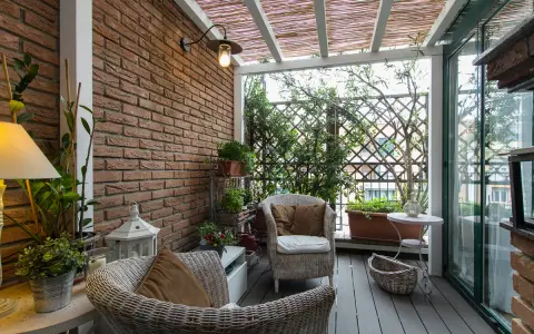 Accogliente veranda piccola con mobili in vimini, piante verdi e un pergolato in bambù. Perfetta per creare un angolo relax.