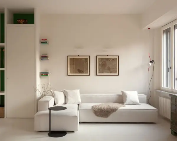 Soggiorno moderno con divano bianco, quadri antichi e un mobile etnico. Idee per case belle da copiare.