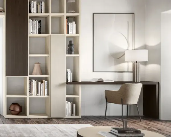 Un piccolo angolo studio in salotto, con libreria componibile, scrivania, sedia e lampada.