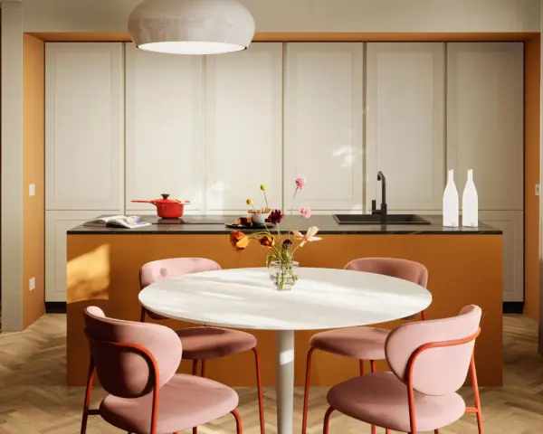 Una casa colorata con un'isola cucina arancione, sedie rosa e un tavolo bianco. Un vaso di fiori aggiunge un tocco di vivacità.