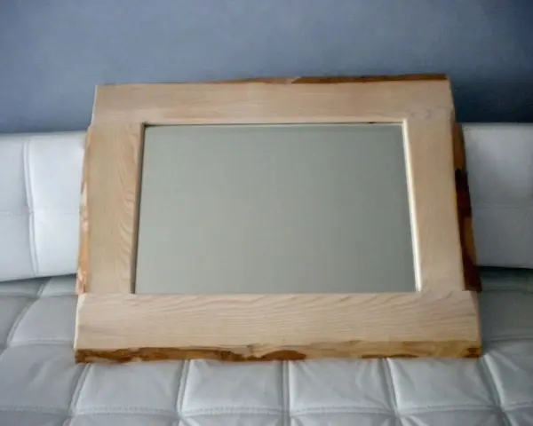 Specchio con cornice in legno grezzo, un'idea per una cornice specchio fai da te rustica e naturale.