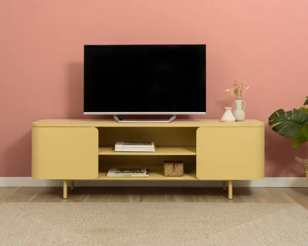 Un mobile giallo vivace con un televisore, riviste e vasi crea una parete tv particolare.