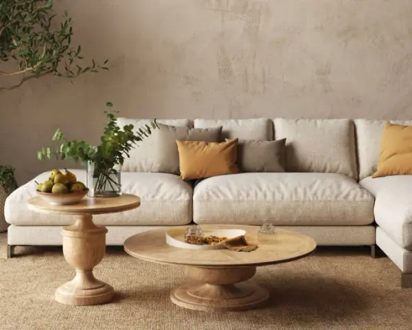 Un accogliente soggiorno con un divano componibile color crema, tavolini in legno e piante. L'arredamento stile contemporaneo crea un'atmosfera rilassante.