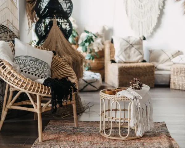 Poltrona in rattan e tavolino con dettagli in macramè, un esempio di design con materiali sostenibili che creano un'atmosfera accogliente.