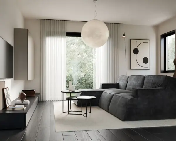 Soggiorno in una casa stile moderno contemporaneo, con divano angolare grigio, tavolini neri, TV a parete e grande lampada sferica.