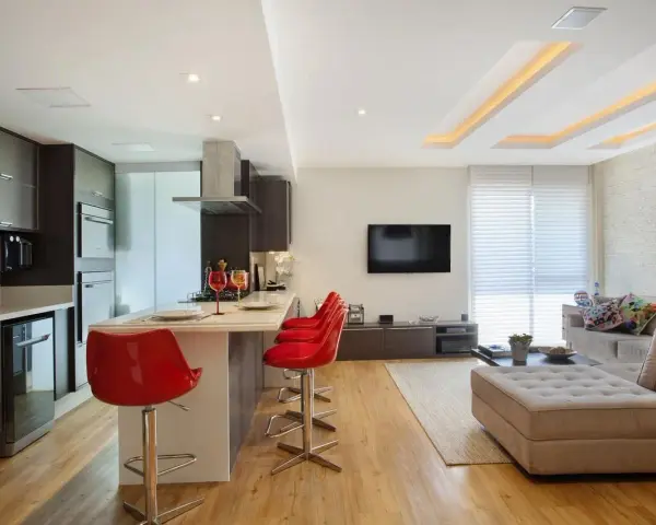 Elegante soggiorno con cucina a vista, illuminato da moderni controsoffitti in cartongesso.