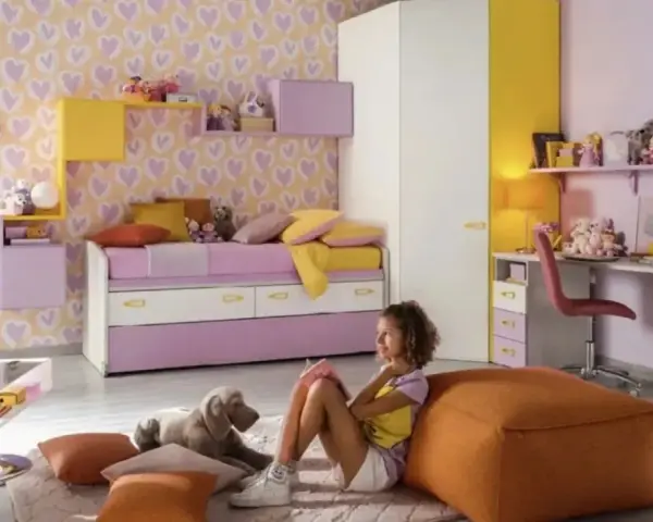 Cameretta bimba con carta da parati a cuori, letto estraibile, scrivania e armadio. Idee colorate e giocose per uno spazio da sogno.