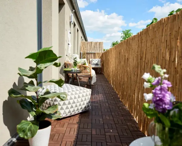 Terrazzo accogliente con mobili in rattan, cuscini decorativi e piante. Le decorazioni terrazzo creano un'oasi di relax.