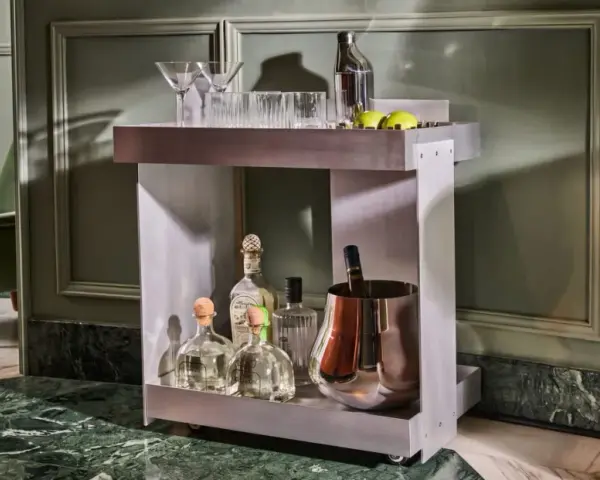 Carrello bar moderno con bottiglie di tequila, bicchieri e secchiello per il ghiaccio. Un'ottima idea per un angolo bar casa elegante.