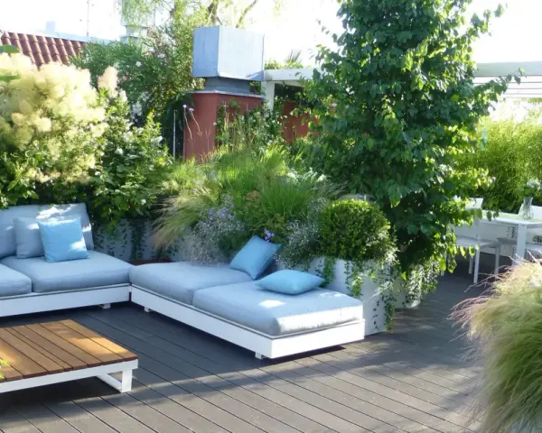 Un lussureggiante giardino sul terrazzo fai da te con divani comodi, tavolino in legno e un tavolo da pranzo.