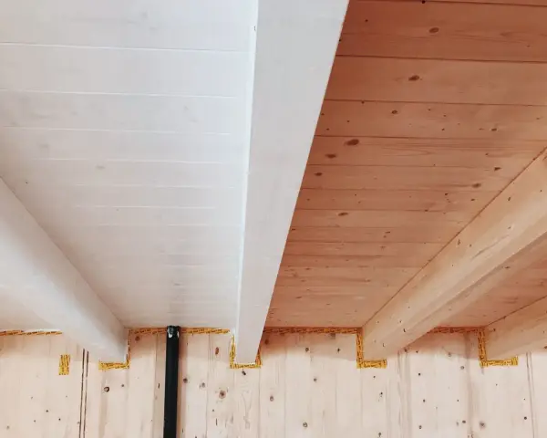 Soffitto perlinato sbiancato con travi a vista in legno naturale. Un contrasto di finiture che crea un ambiente caldo e luminoso.