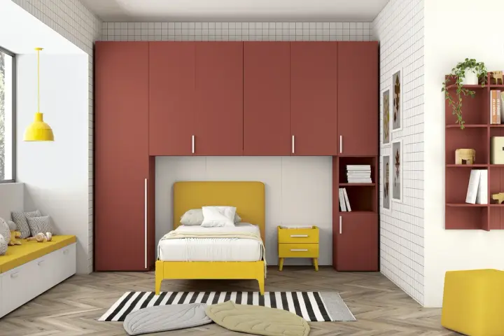 Soluzione perfetta per organizzare armadio a ponte bambini: letto giallo, armadi rossi e tanto spazio per giocare.