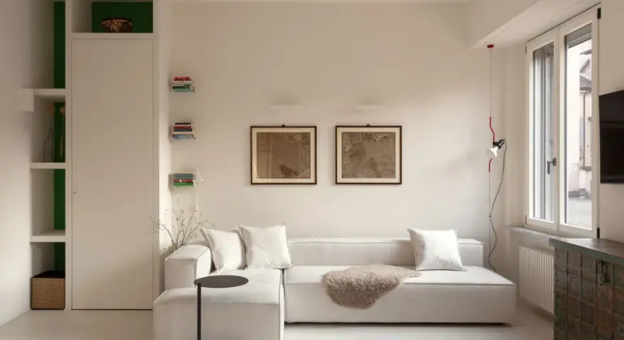 Soggiorno moderno con divano bianco, quadri antichi e un mobile etnico. Idee per case belle da copiare.