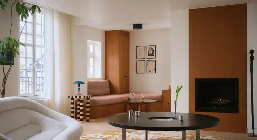 Un elegante soggiorno con un design **art deco interior design**, mobili in legno, un camino e una poltrona soffice.