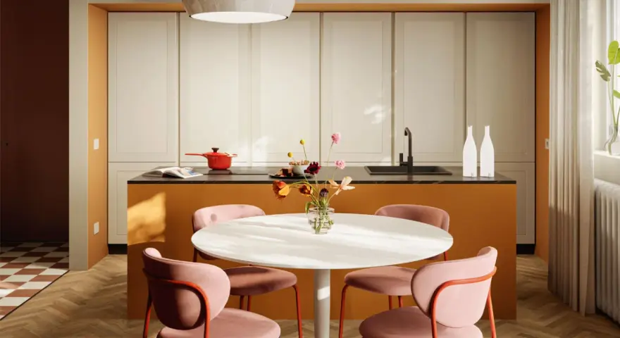 Una casa colorata con un'isola cucina arancione, sedie rosa e un tavolo bianco. Un vaso di fiori aggiunge un tocco di vivacità.