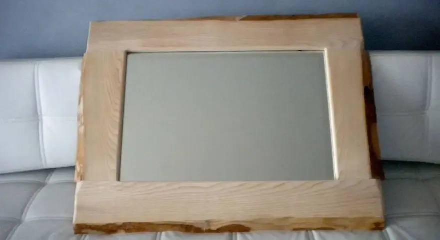 Specchio con cornice in legno grezzo, un'idea per una cornice specchio fai da te rustica e naturale.