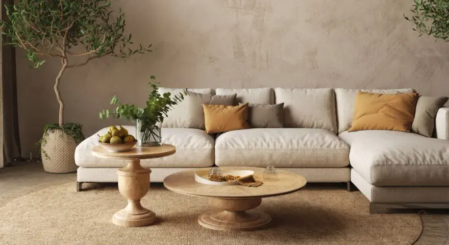 Un accogliente soggiorno con un divano componibile color crema, tavolini in legno e piante. L'arredamento stile contemporaneo crea un'atmosfera rilassante.