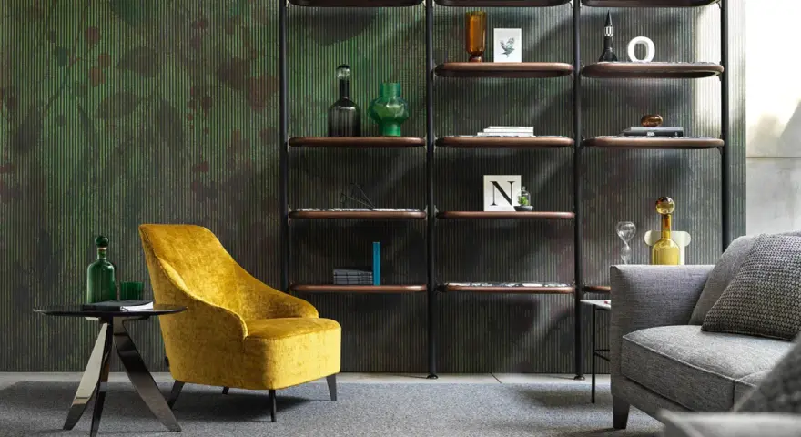 Un comodo angolo lettura con poltrona gialla, tavolino nero e libreria a parete con oggetti decorativi.