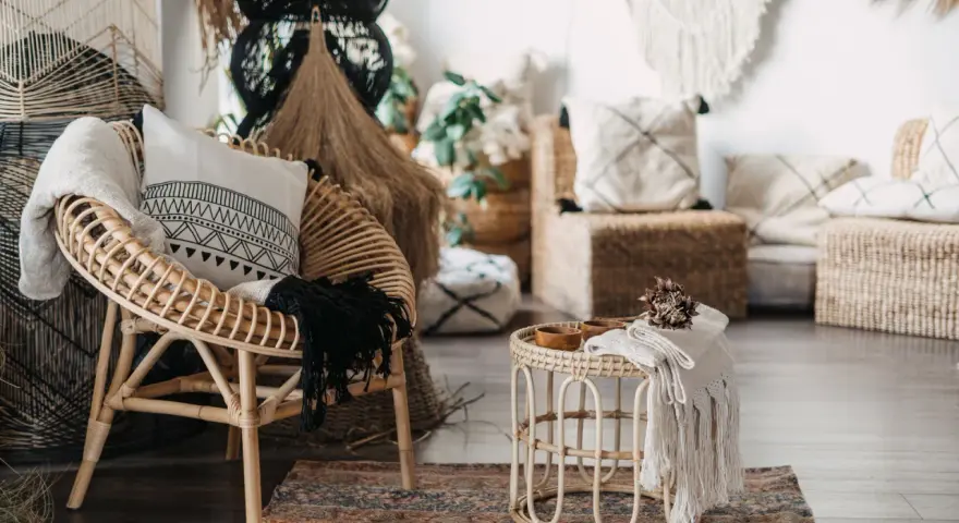 Poltrona in rattan e tavolino con dettagli in macramè, un esempio di design con materiali sostenibili che creano un'atmosfera accogliente.