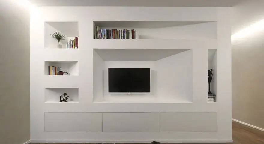 Una moderna parete in cartongesso con nicchie per libri, TV e decorazioni.