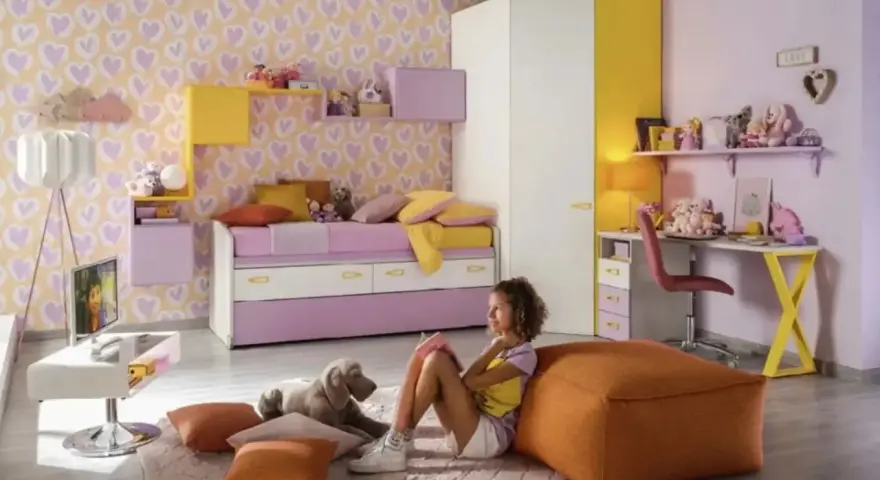 Cameretta bimba con carta da parati a cuori, letto estraibile, scrivania e armadio. Idee colorate e giocose per uno spazio da sogno.