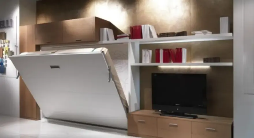 Soluzione salvaspazio per come arredare una casa piccola: letto a scomparsa integrato con libreria e mobile TV.