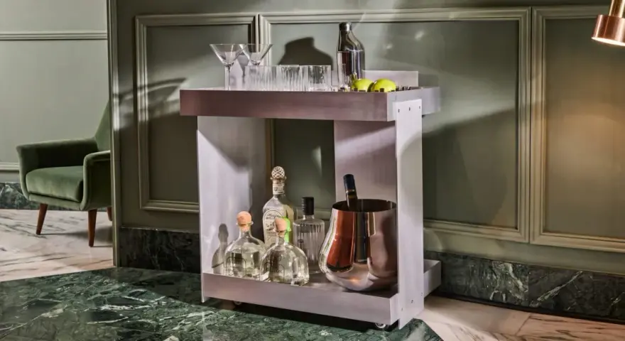 Carrello bar moderno con bottiglie di tequila, bicchieri e secchiello per il ghiaccio. Un'ottima idea per un angolo bar casa elegante.