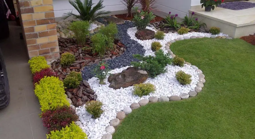 Piccoli giardini da sogno con ghiaia bianca, pietre scure, piante verdi e fiori rossi, un'oasi di pace.