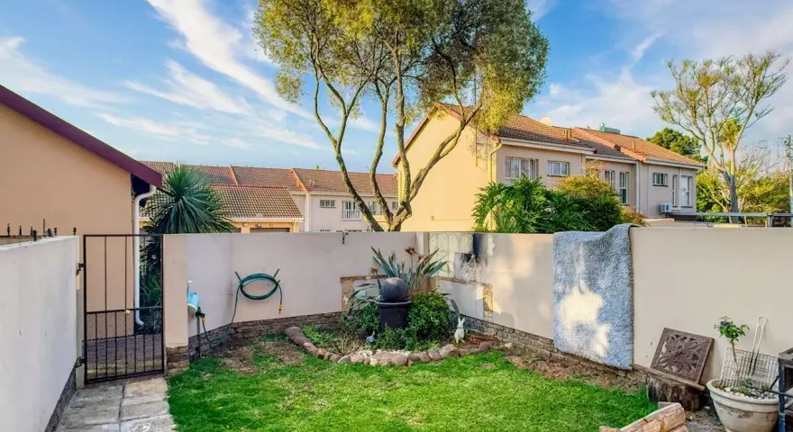 Giardino con prato verde, piante e un piccolo laghetto. Idee per come abbellire un giardino con pochi soldi, con mobili riciclati e decorazioni fai-da-te.
