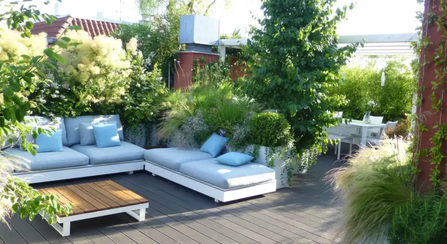 Un lussureggiante giardino sul terrazzo fai da te con divani comodi, tavolino in legno e un tavolo da pranzo.