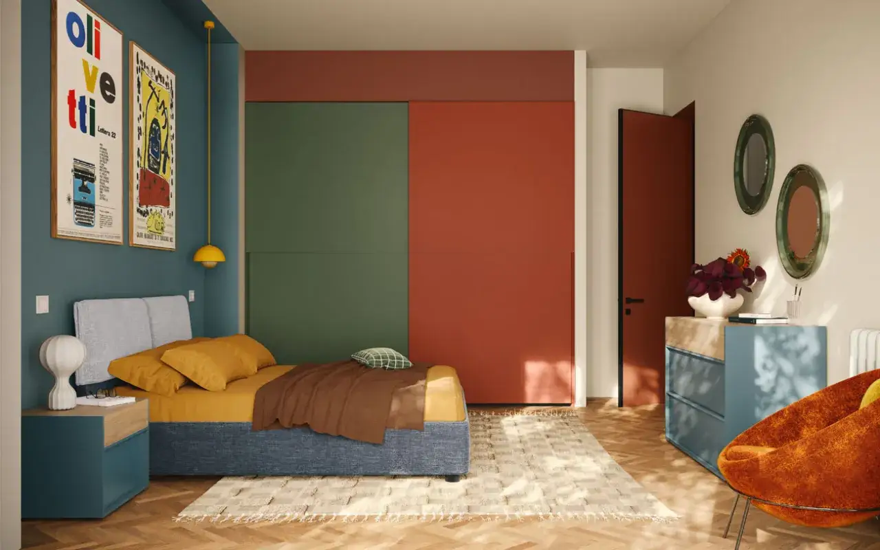 Una camera da letto con un letto blu, cuscini gialli e una coperta marrone. Pareti colorate, un armadio verde e rosso, e una porta rossa. Una casa colorata e moderna.
