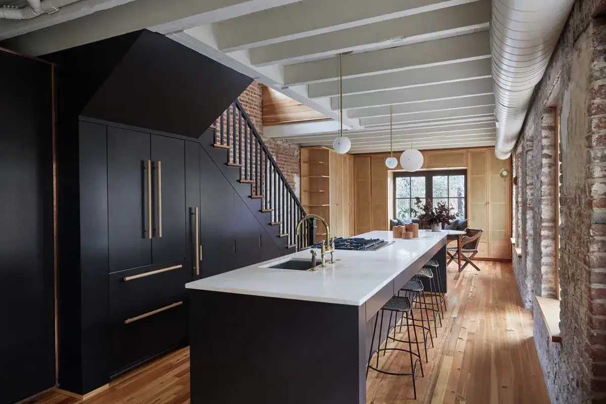 Moderna cucina con isola centrale e scala a vista, un'accogliente piccola tavernetta casa.