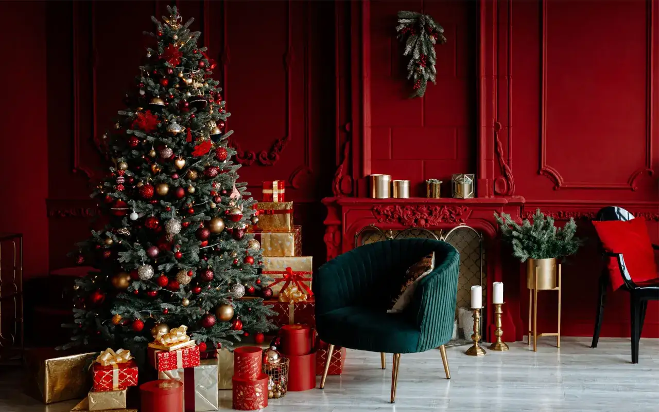 Albero di Natale addobbato con palline rosse e oro, circondato da regali. Un'ispirazione per le tue idee albero di Natale rosso e oro.