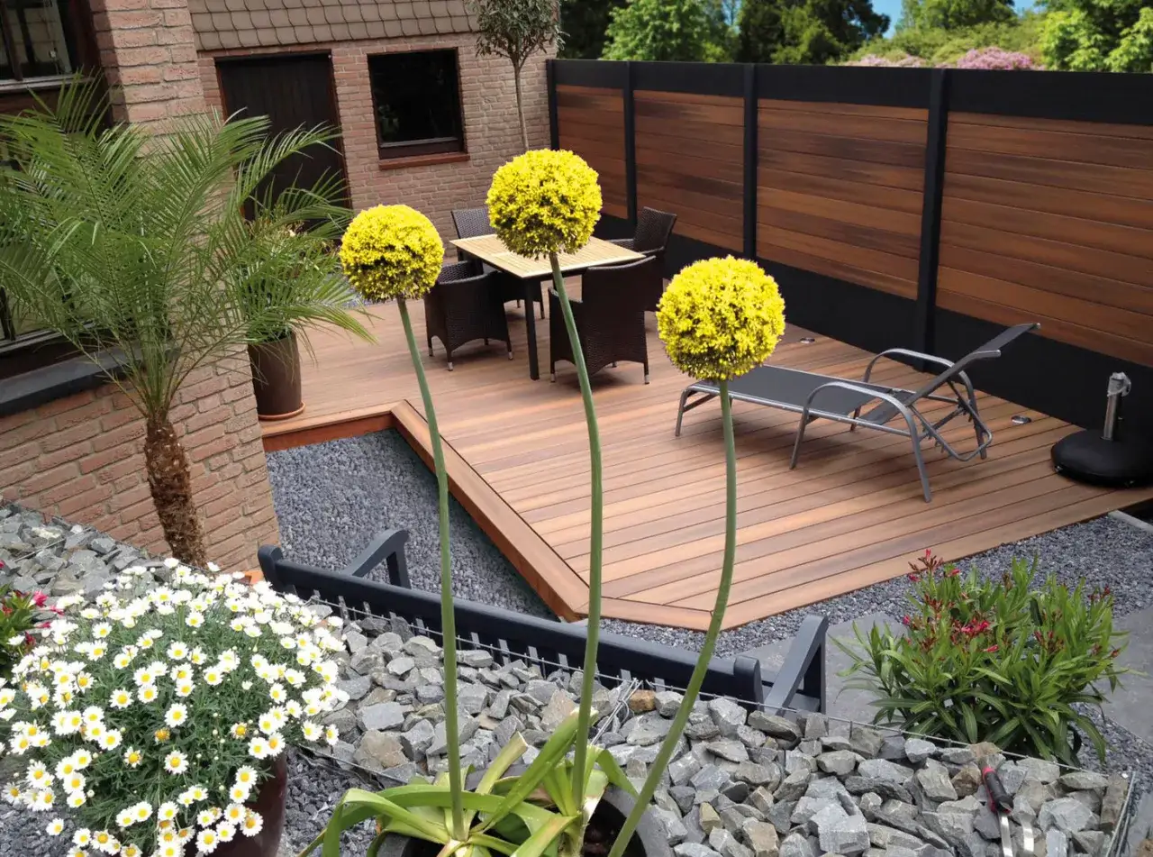 Giardino moderno con deck in legno, ghiaia e piante ornamentali. Esempi idee giardino senza erba: un'oasi di design.