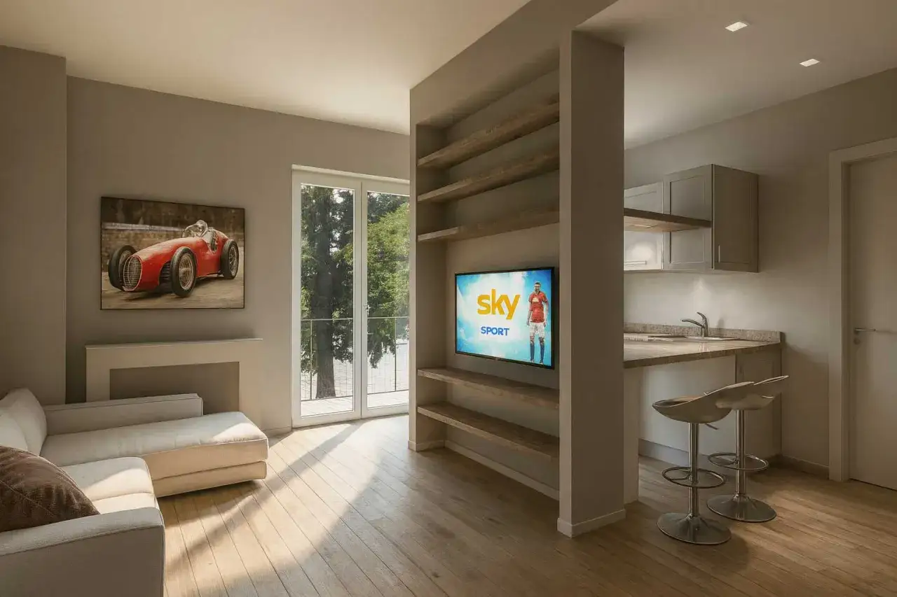 Un soggiorno moderno con divano, quadro d'auto d'epoca e cucina a vista. Un consulente d'arredo ha creato questo spazio funzionale e di stile.