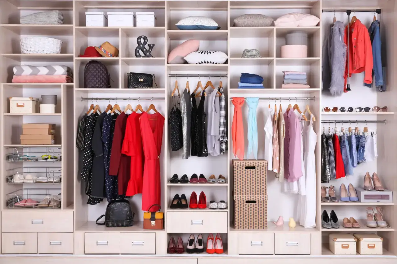 Disposizione interno armadio con abiti, scarpe, borse e accessori. La divisione interna è ben organizzata per ogni categoria.