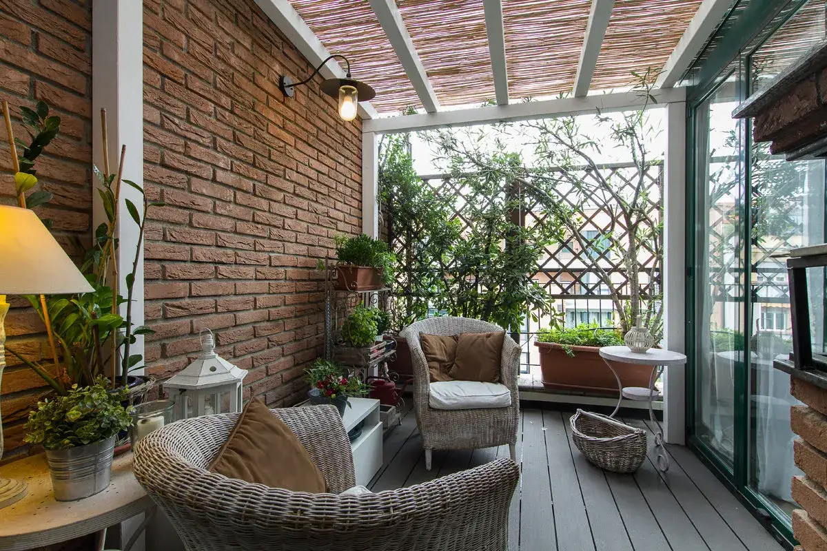 Veranda piccola arredata con mobili in vimini, piante e illuminazione soffusa. Idee per arredare una veranda piccola con stile e comfort.