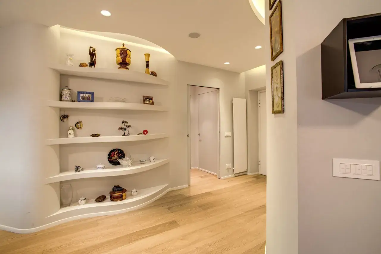 Idee mensole in cartongesso con illuminazione integrata, perfette per esporre oggetti decorativi in un soggiorno moderno.