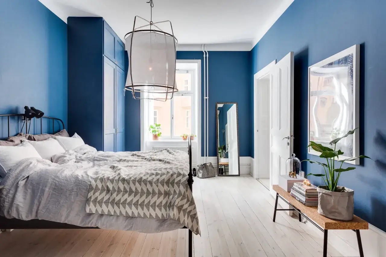 Accogliente camera da letto blu con letto comodo, armadio capiente e specchio a figura intera.