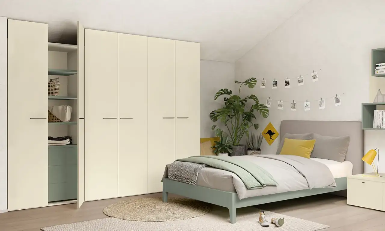 Camera da letto moderna con letto una piazza e mezza, armadio bianco e piante verdi.