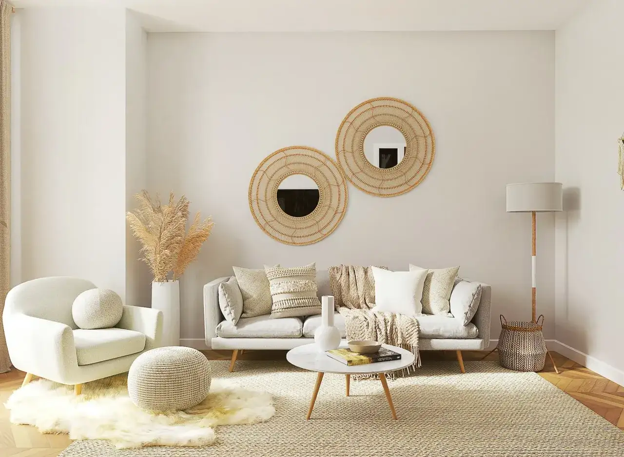 Salotto con divano grigio, poltrona bianca, tavolino rotondo in marmo e specchi decorativi in rattan. Un'oasi di arredamento contemporaneo chic.
